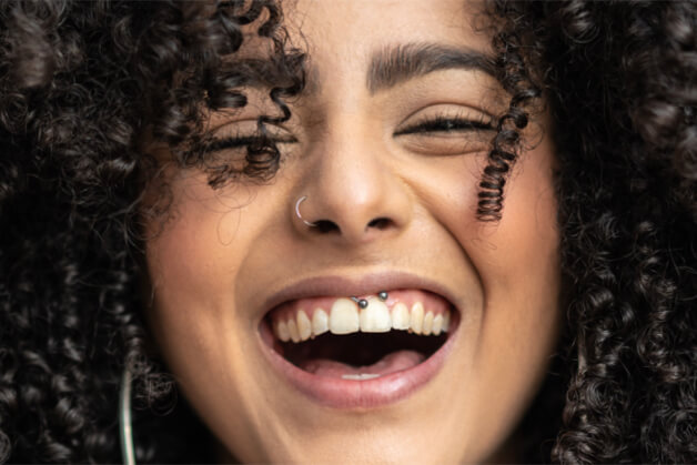 Une fille aux cheveux bouclés souriant à la caméra