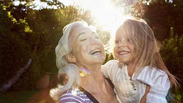 Une grand-mère avec sa petite-fille souriant au coucher du soleil