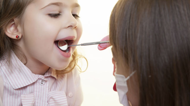 Un dentiste examinant les dents d'une petite fille