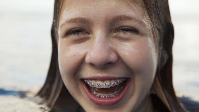 Une fille sortant de l'eau en souriant