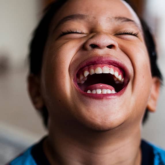 toddler laughing and showing teeth 